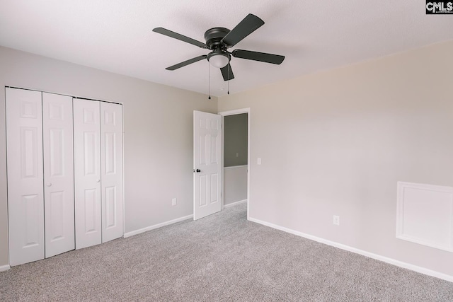 unfurnished bedroom featuring ceiling fan, a closet, carpet flooring, and baseboards