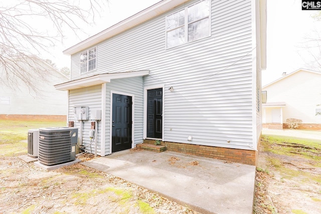 rear view of property with entry steps, central AC, and a patio