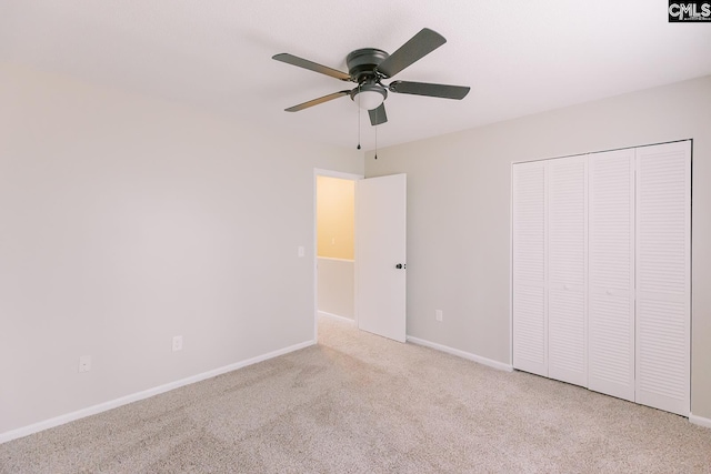 unfurnished bedroom featuring ceiling fan, a closet, carpet, and baseboards