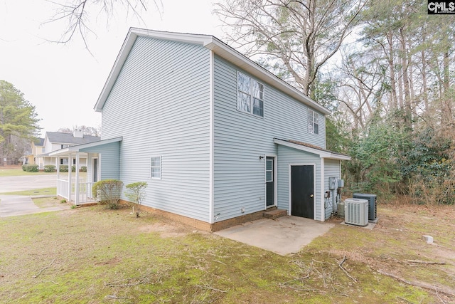 view of side of home featuring a patio area, central AC unit, and a yard