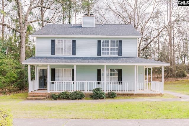 farmhouse featuring covered porch, roof with shingles, a chimney, and a front yard