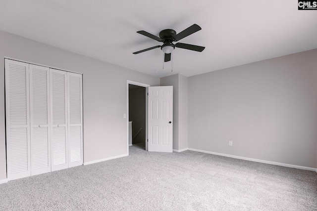 unfurnished bedroom featuring a closet, carpet, a ceiling fan, and baseboards