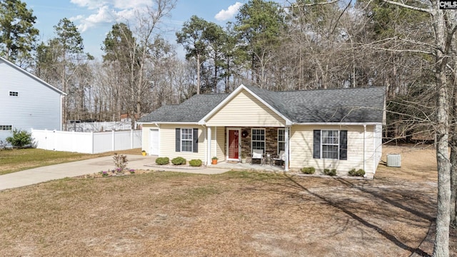 view of front of property with central AC unit, covered porch, fence, roof with shingles, and a front lawn