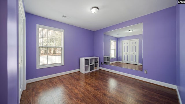 empty room featuring visible vents, baseboards, and wood finished floors