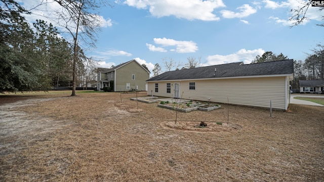 back of property featuring a garden