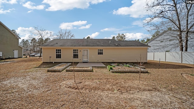 back of property with a patio area, fence, and a garden