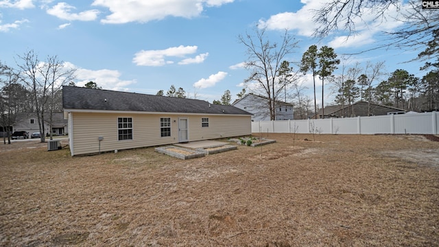 rear view of house featuring a yard, fence, a vegetable garden, and central air condition unit