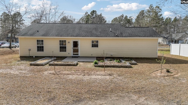 back of house featuring a patio area, fence, and roof with shingles