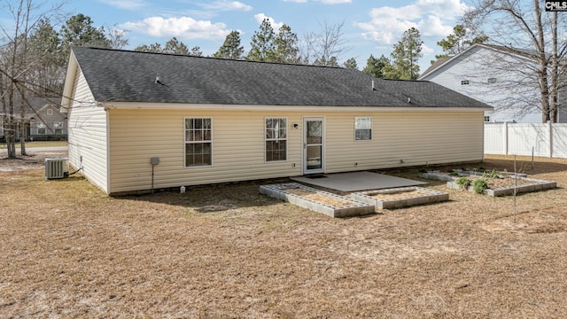 rear view of property featuring a patio, central air condition unit, fence, a garden, and roof with shingles