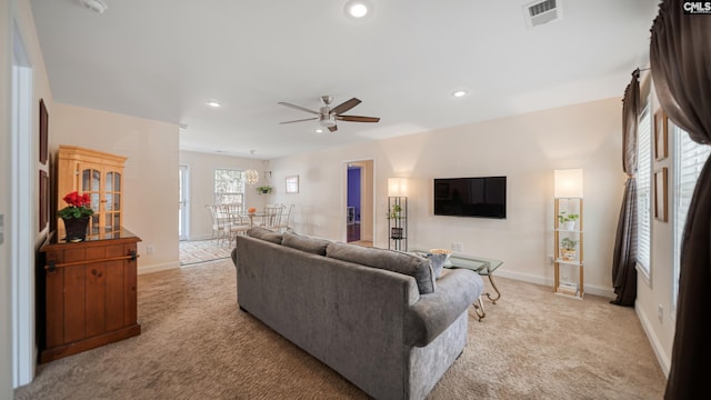 living area featuring baseboards, recessed lighting, visible vents, and light colored carpet