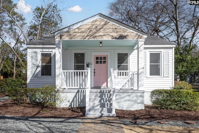 bungalow featuring a shingled roof and a porch