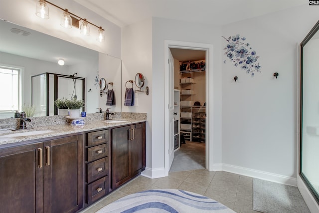 bathroom with tile patterned flooring, a sink, and a shower stall