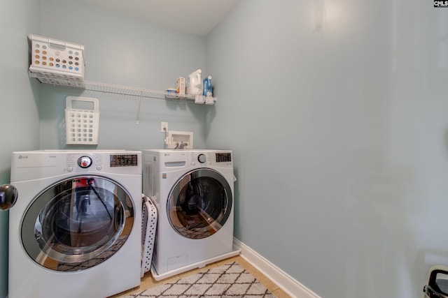 washroom with laundry area, baseboards, and independent washer and dryer