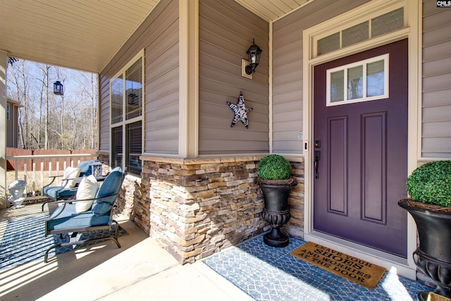 entrance to property with covered porch and stone siding