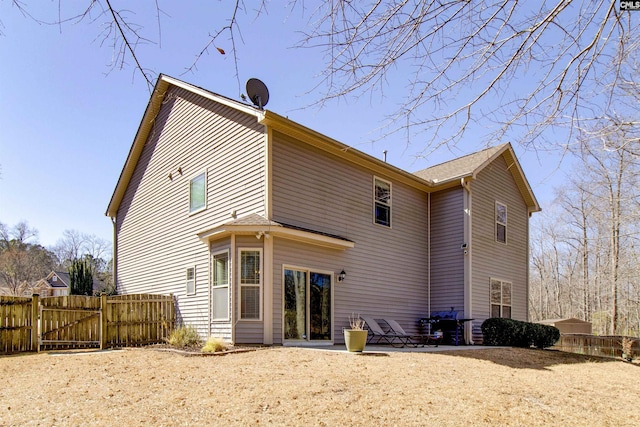 back of house with a gate, fence, and a patio