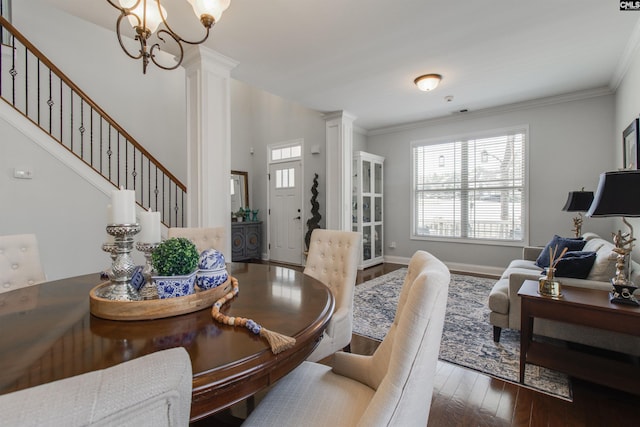 dining area with decorative columns, baseboards, stairway, wood finished floors, and a chandelier