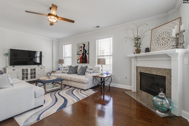 living room with a fireplace, visible vents, ornamental molding, wood finished floors, and baseboards