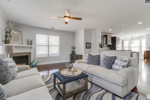 living room featuring a healthy amount of sunlight, crown molding, and wood finished floors