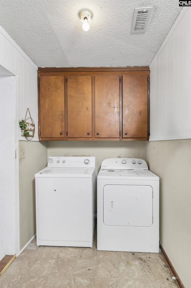 clothes washing area featuring cabinet space, visible vents, a textured ceiling, and independent washer and dryer