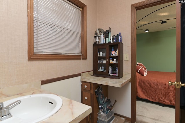 ensuite bathroom with wallpapered walls, a sink, and ensuite bathroom