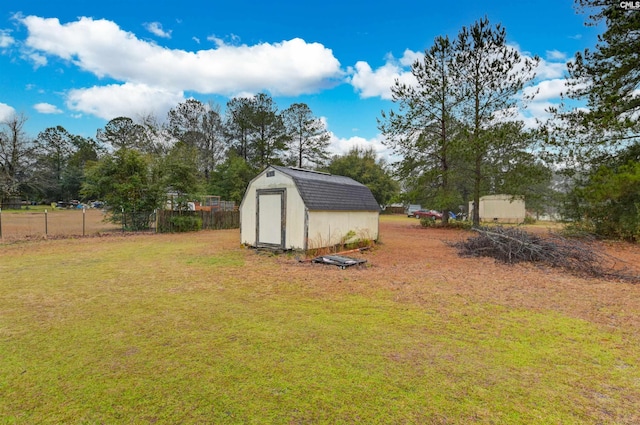 view of yard featuring a shed, fence, and an outdoor structure