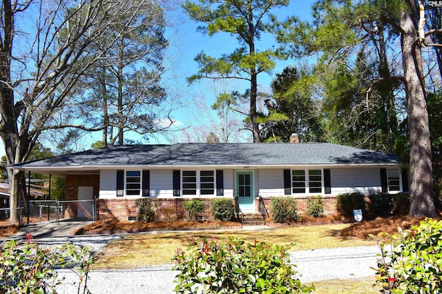 ranch-style home featuring crawl space, driveway, a carport, and brick siding