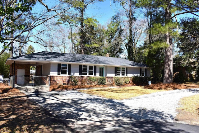 single story home with brick siding, a chimney, fence, an attached carport, and driveway