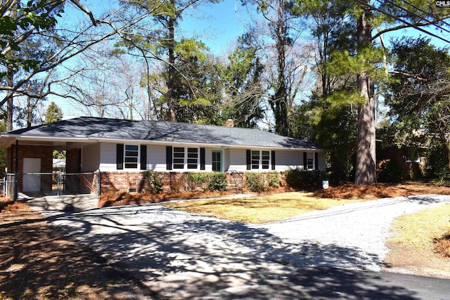 ranch-style house with an attached carport, brick siding, driveway, crawl space, and a chimney