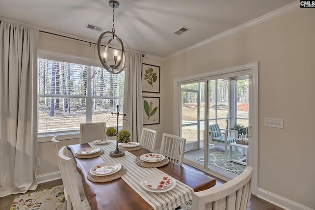 dining room featuring ornamental molding, wood finished floors, visible vents, and an inviting chandelier