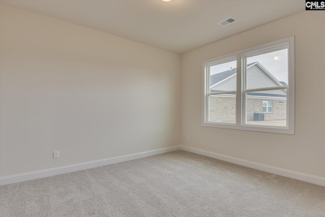 unfurnished room with carpet floors, visible vents, and baseboards