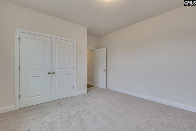 unfurnished bedroom featuring carpet floors, a closet, and baseboards