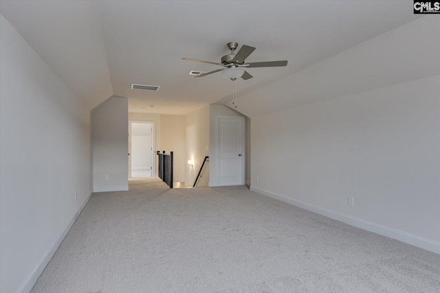 additional living space with lofted ceiling, baseboards, visible vents, and light colored carpet