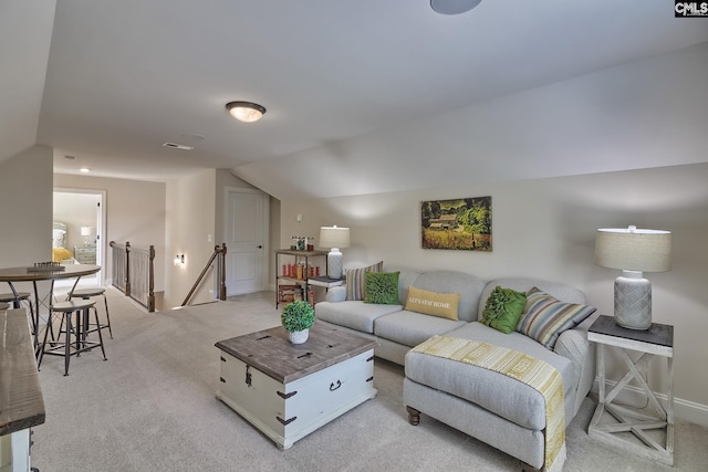 living area with lofted ceiling, light colored carpet, and baseboards