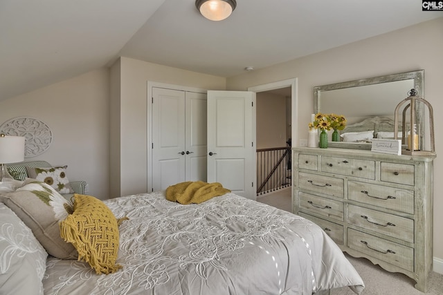 carpeted bedroom featuring lofted ceiling and a closet