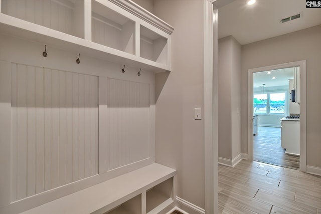 mudroom with light wood-type flooring, visible vents, and baseboards