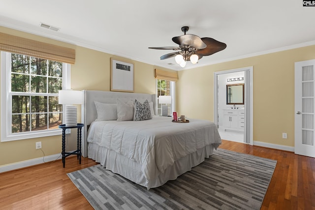 bedroom featuring ornamental molding, baseboards, and wood finished floors