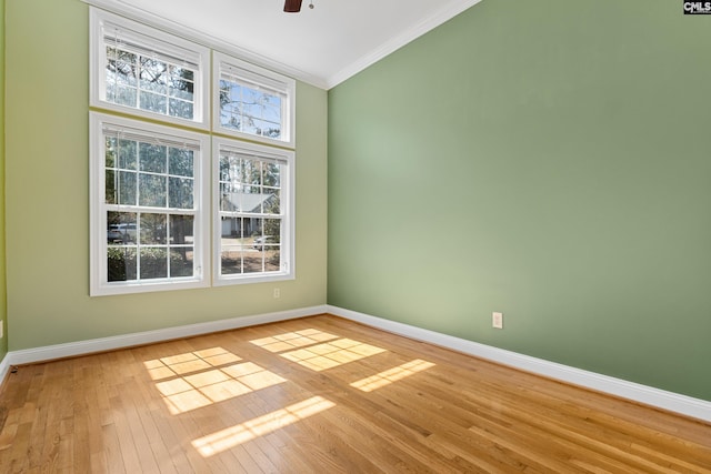 unfurnished room featuring light wood-type flooring, baseboards, ornamental molding, and ceiling fan