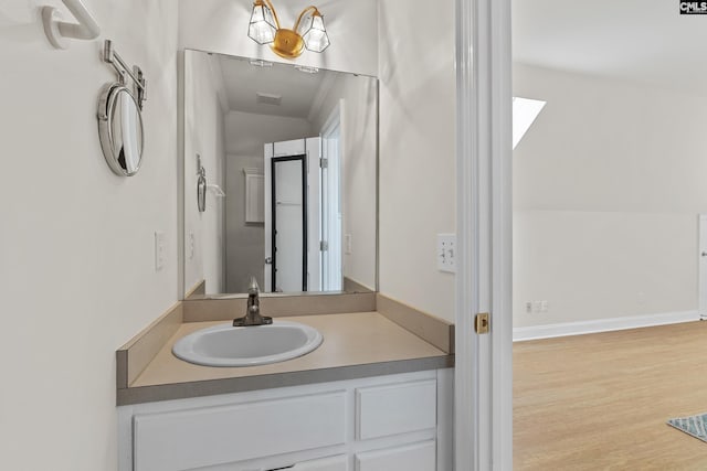 bathroom featuring wood finished floors, vanity, and baseboards