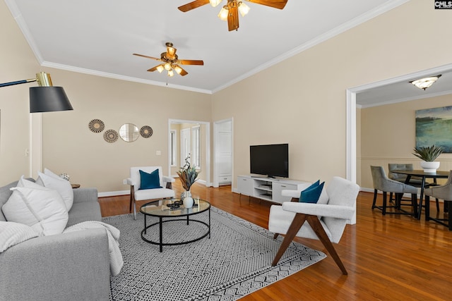 living area featuring ceiling fan, ornamental molding, wood finished floors, and baseboards