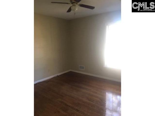 unfurnished room featuring a ceiling fan, dark wood-style flooring, and baseboards