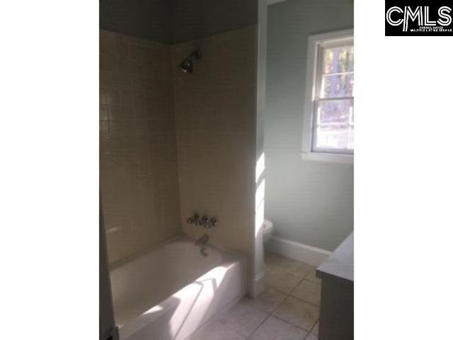 bathroom with shower / bathtub combination, toilet, vanity, tile patterned flooring, and baseboards