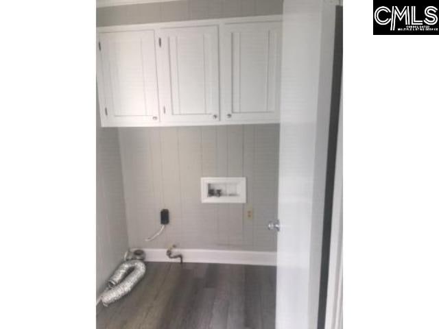 washroom with hookup for a washing machine, cabinet space, gas dryer hookup, wood finished floors, and baseboards