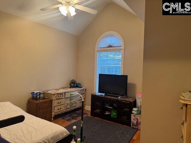 bedroom with vaulted ceiling, ceiling fan, and wood finished floors