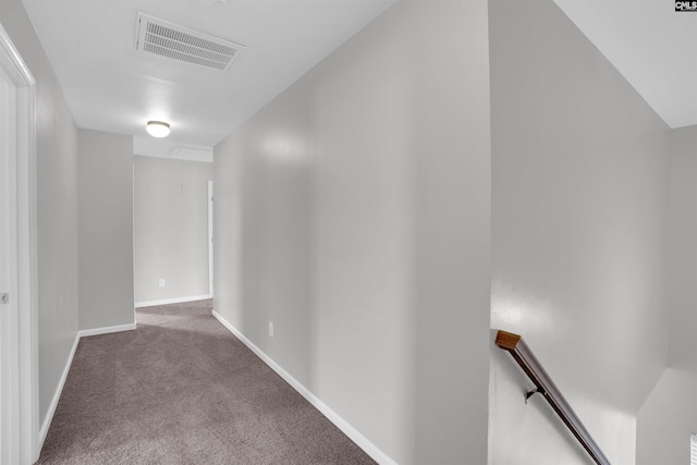 corridor featuring carpet floors, an upstairs landing, baseboards, visible vents, and attic access