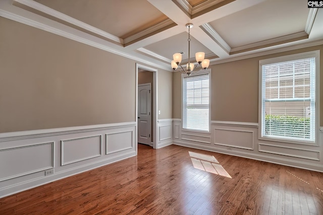 spare room featuring coffered ceiling, wood-type flooring, crown molding, beamed ceiling, and a chandelier