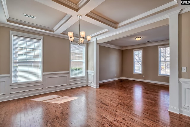 unfurnished room featuring an inviting chandelier, crown molding, wood finished floors, and a healthy amount of sunlight