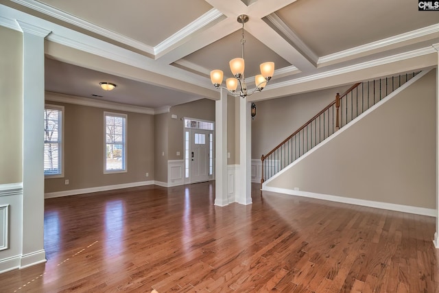 interior space with beamed ceiling, ornamental molding, wood finished floors, a notable chandelier, and coffered ceiling