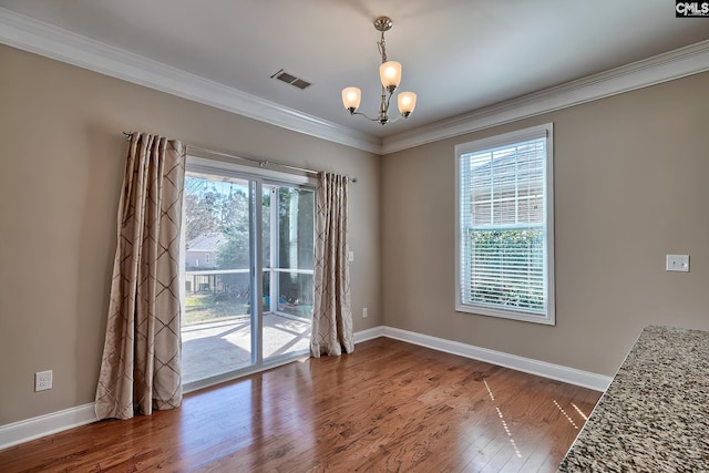 unfurnished dining area with wood finished floors, visible vents, baseboards, an inviting chandelier, and crown molding