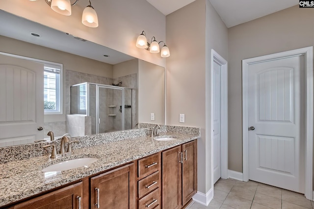 bathroom with tile patterned flooring, a shower stall, double vanity, and a sink