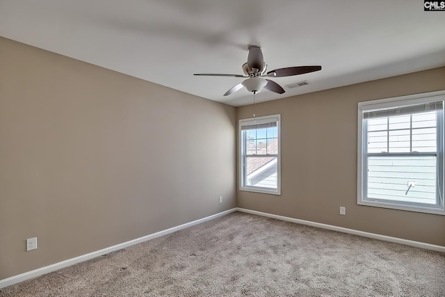 carpeted empty room featuring visible vents, baseboards, and a ceiling fan